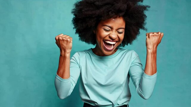 A joyful woman with clenched fists celebrates success. Captured from a front angle, the vibrant style is ideal for a motivational video theme.