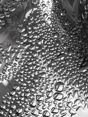 Close-up of water droplets on a shiny metal surface.