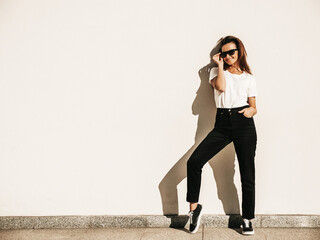 Portrait of beautiful smiling model in sunglasses. Female dressed in summer hipster white T-shirt...