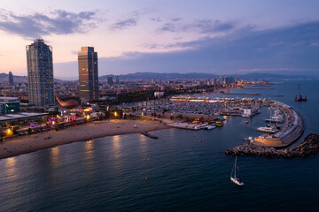Obraz premium Picturesque evening aerial view of coastal area of Barcelona overlooking Olympic Harbor marina with moored pleasure yachts and modern architecture of waterfront in summer, Spain..