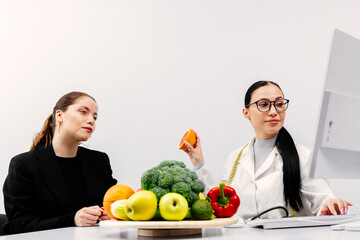 Female nutritionist giving nutritional advice to young woman. Weight loss concept, calorie burning...