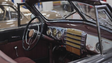 Interior view of vintage convertible car showing steering wheel and dashboard