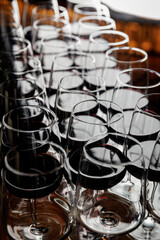 Multiple wine glasses filled with red wine are neatly arranged on a table in a restaurant setting