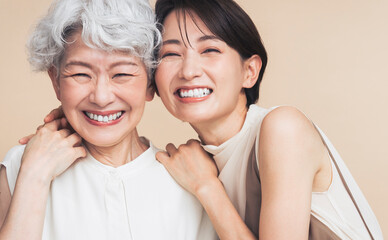アジア人母娘ポートレート。彼女たちは寄り添い笑っている。	