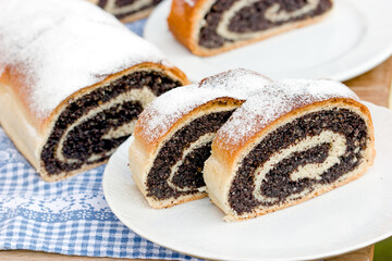Slice of poppy seed strudel on plate, homemade poppy seed roll
