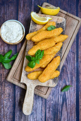  Crispy home made  deep fried   chicken strips . Breaded  with cornflakes chicken  breast fillets  with chilly peppers and fresh   basil on wooden rustic background