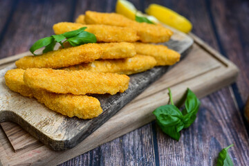  Crispy home made  deep fried   chicken strips . Breaded  with cornflakes chicken  breast fillets  with chilly peppers and fresh   basil on wooden rustic background