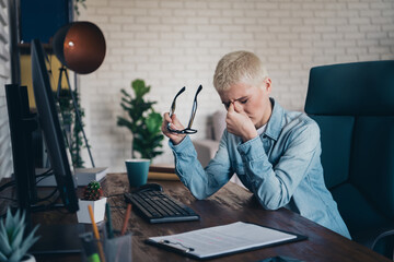 Young professional woman feeling tired at work wearing a denim shirt