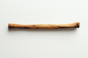 A single elongated piece of dried wood presented against a plain backdrop