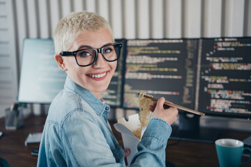 Young Professional Programmer Enjoying a Meal While Working in a Modern Office Space