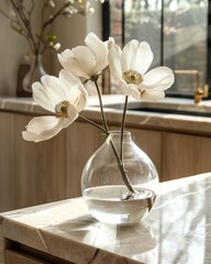 Delicate White Flowers in a Clear Vase on a Marble Countertop