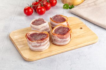 Raw pork tenferloin with bacon