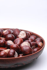 Lots of chestnuts in plate on white background.