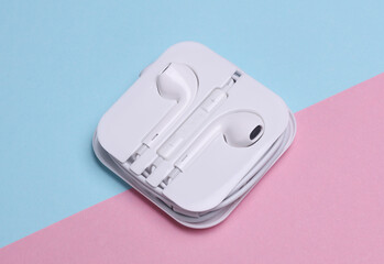 white Wire earphones on blue pink background