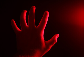 Obraz premium Male hand in red neon light