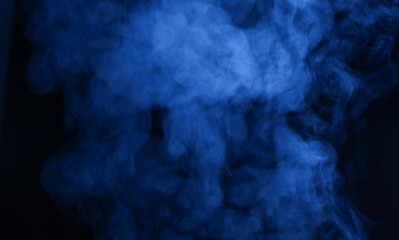 Steam or smoke in blue neon light on black background