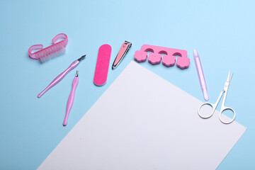 Nail care tools, manicure set with white blank paper sheet on blue background. Space for your text and information. Flat lay. Top view