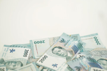A stack of two thousand rupiah banknotes with negative space, Indonesian money. suitable for background, finance, banking, cash, savings.