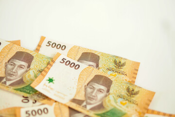 a stack of five thousand rupiah banknotes with negative space, which is Indonesia. suitable for background, finance, banking, cash, savings.