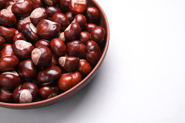 Lots of chestnuts in a bowl on white background. Top view