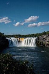 Fototapeta premium there is a large waterfall that is flowing over a cliff