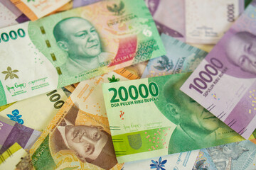 Various stacks of Indonesian banknotes, from one thousand rupiah to twenty thousand rupiah. Suitable for background, finance, banking, cash, savings.