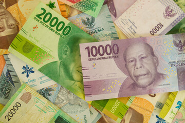 Various stacks of Indonesian banknotes, from one thousand rupiah to twenty thousand rupiah. Suitable for background, finance, banking, cash, savings.