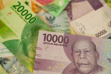 Various stacks of Indonesian banknotes, from one thousand rupiah to twenty thousand rupiah. Suitable for background, finance, banking, cash, savings.
