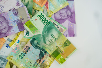 stack of various Indonesian banknotes with negative space, from one thousand rupiah to twenty thousand rupiah. Suitable for background, finance, banking, cash, savings.