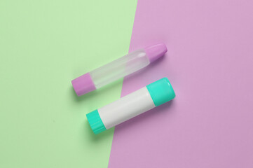 Glue stick for paper on pink blue background