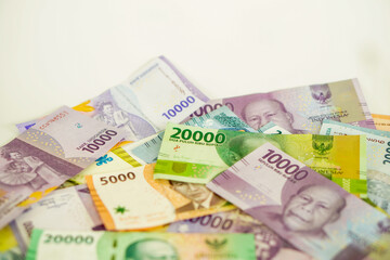 stack of various Indonesian banknotes with negative space, from one thousand rupiah to twenty thousand rupiah. Suitable for background, finance, banking, cash, savings.