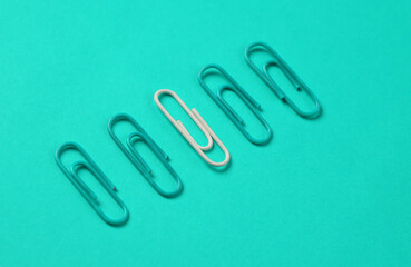 Blue and white paper clips on blue background. Creative layout. Business concept. Exclusivity, uniqueness. Do not be like everyone else