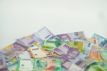 stack of various Indonesian banknotes with negative space, from one thousand rupiah to twenty thousand rupiah. Suitable for background, finance, banking, cash, savings.