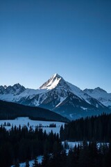 mountains with snow on them and a few trees in the foreground