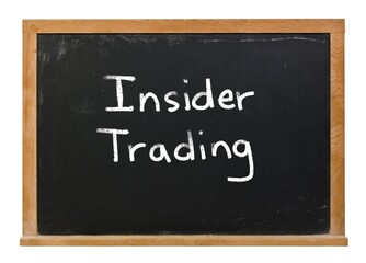 Obraz premium Insider trading written in white chalk on a black chalkboard