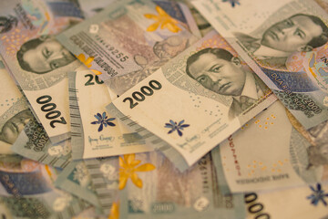 A stack of two thousand rupiah banknotes, Indonesian money. suitable for background, finance, banking, cash, savings.