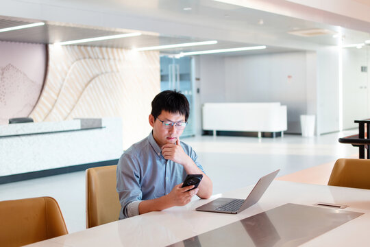 asian businessman working with laptop and smart phone in office - Powered by Adobe