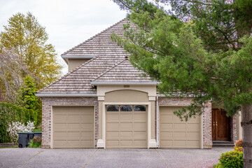 Garage door in luxury house with trees and nice landscape in Spring in Vancouver, Canada, North...