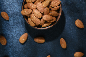 Top view of almonds in wooden bowl healthy food concept..