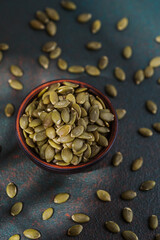 Pumpkin seeds in wooden bowl on textured background healthy snack