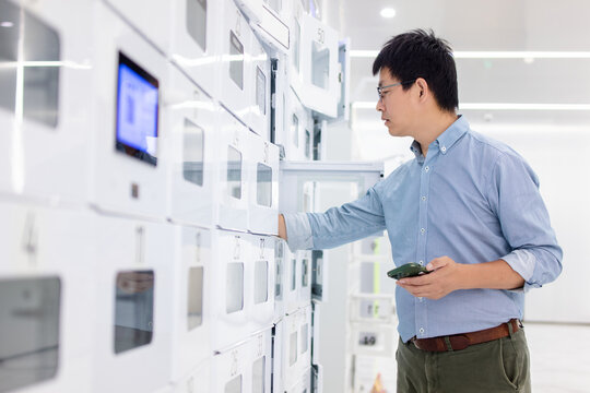 An Asian man is in front of the express delivery locker