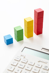 白背景に電卓と積み木のグラフ
