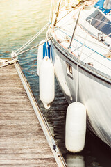 Sailboat moored at wooden dock, nautical scene in sunlight