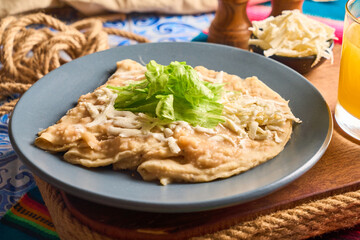 Enfrijoladas with fresh cheese and lettuce, a delicious mexican food