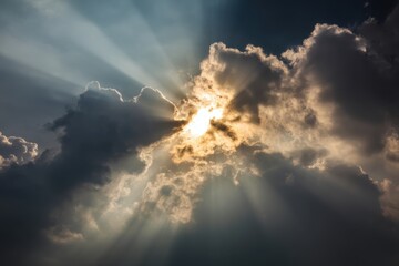 Sunburst Through Clouds: An awe-inspiring image capturing the radiant sun breaking through dramatic clouds, creating a breathtaking display of light and shadow. 