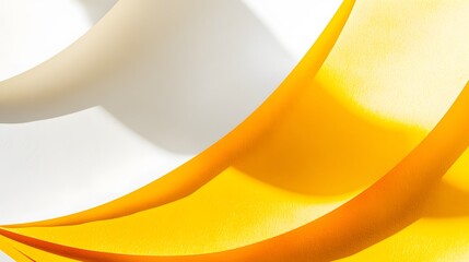 Abstract flowing yellow and beige fabric curves on white background creating elegant design.