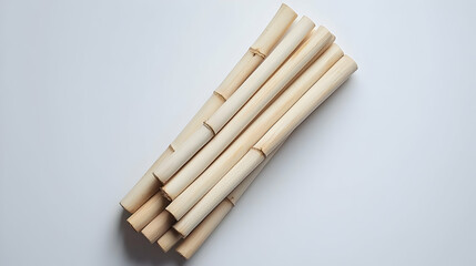 Stacked Light Beige Bamboo Sticks On White Background