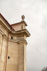 Old building facade featuring broken windows and peeling paint in an urban setting under natural light. Historical church Krakovets, Ukraine