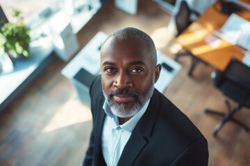 wide angle above portrait of a Middle aged african american businessman looking at camera in office