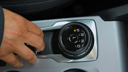 Woman's fingers activate the Hand brake in the car. Close-up view in the vehicle, the electric parking brake. Driving modern car.